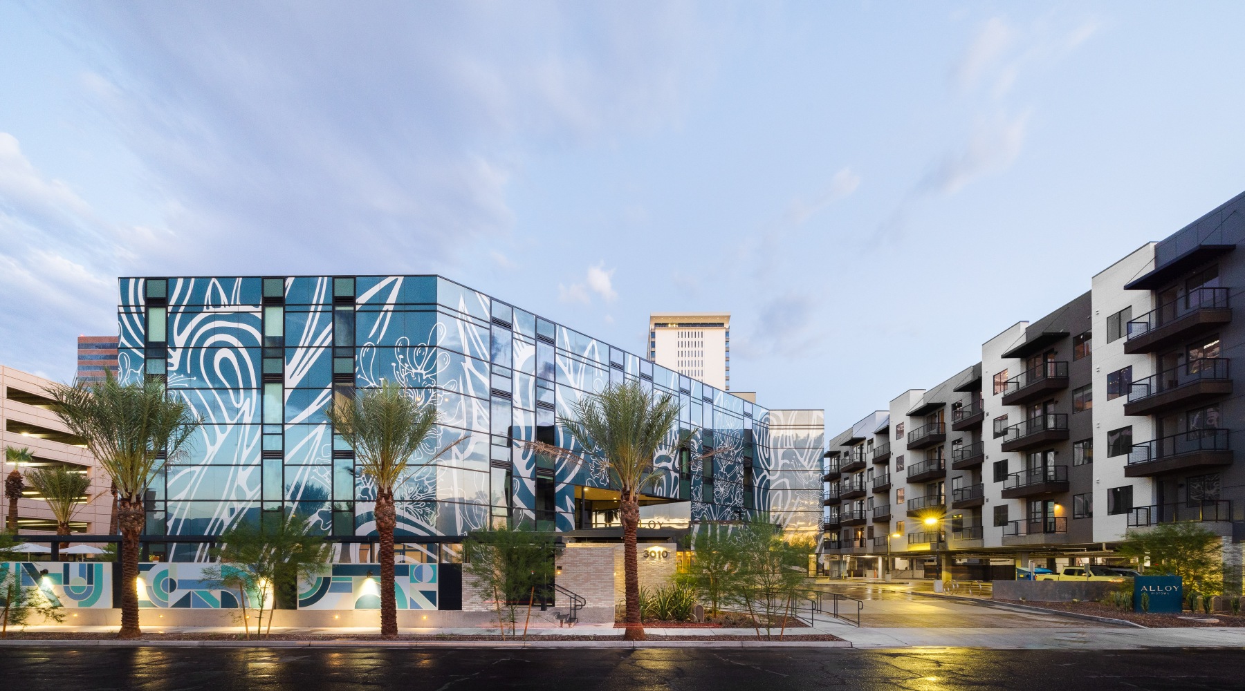 Desert alchemy Building with mural across from Balconied new building