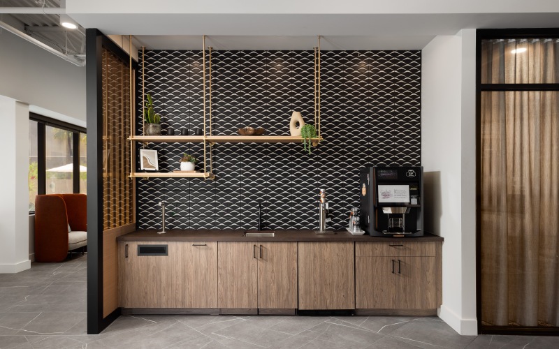 Luxurious hospitality bar with top of the line coffee maker and black backsplash
