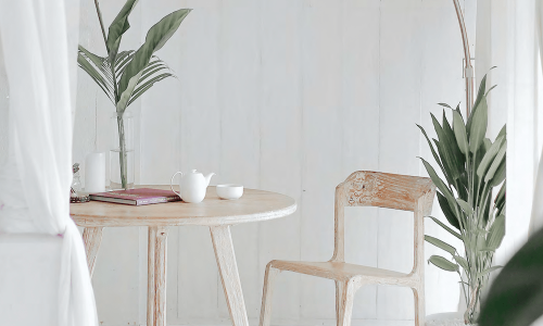 a table and a chair in a bright room